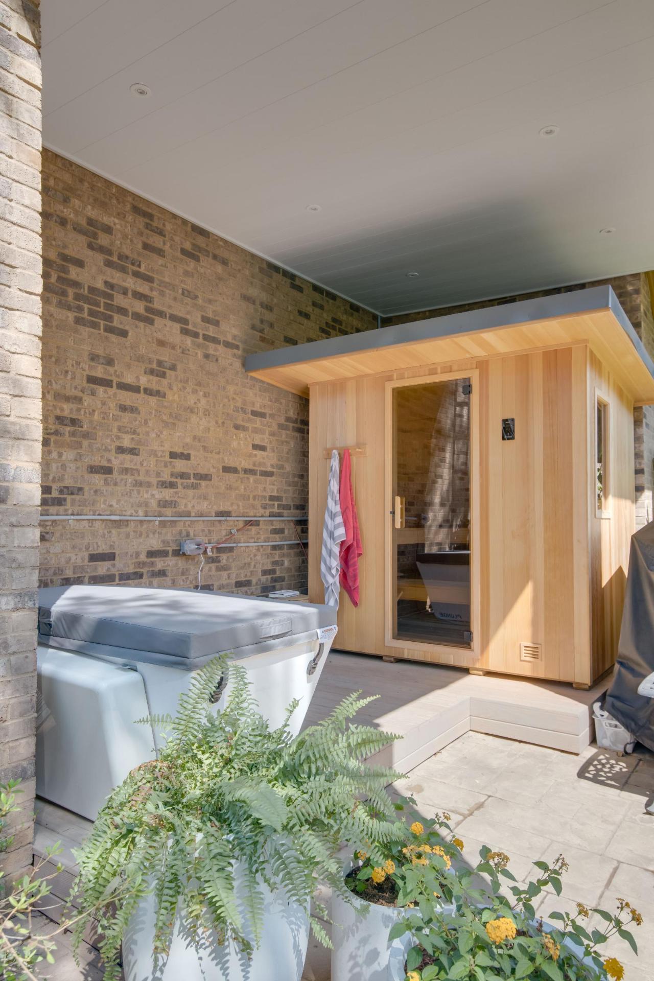 Outdoor cedar sauna with hot tub on patio